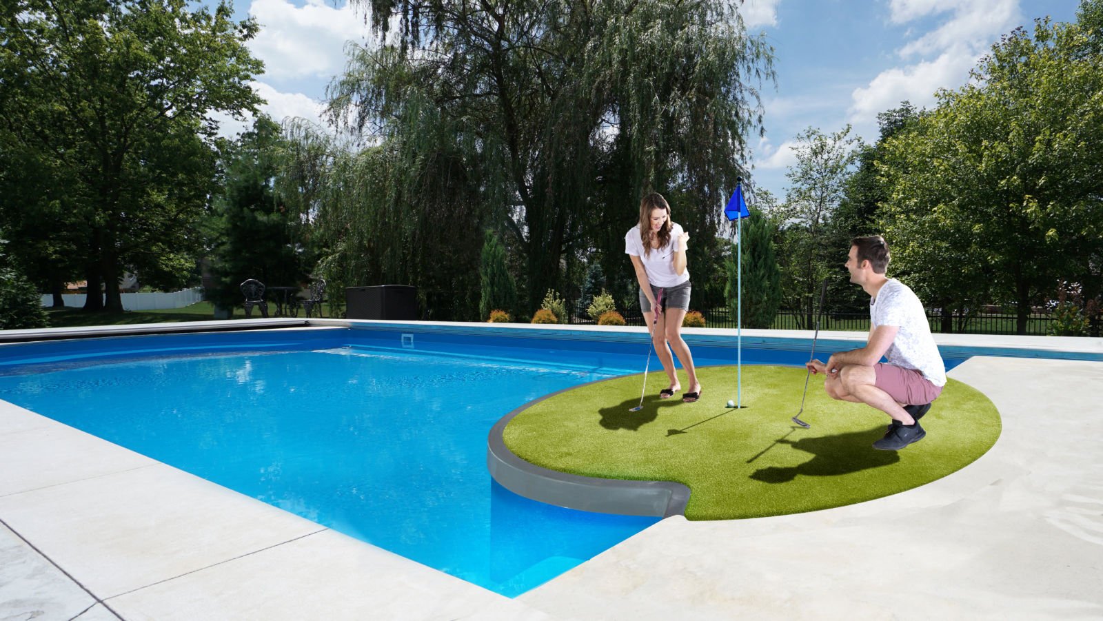 Eye-level view of a large rectangular blue fiberglass swimming pool featuring a custom round artificial turf putting green built into the specialized pool extension, with a couple playing mini-golf beside the water.