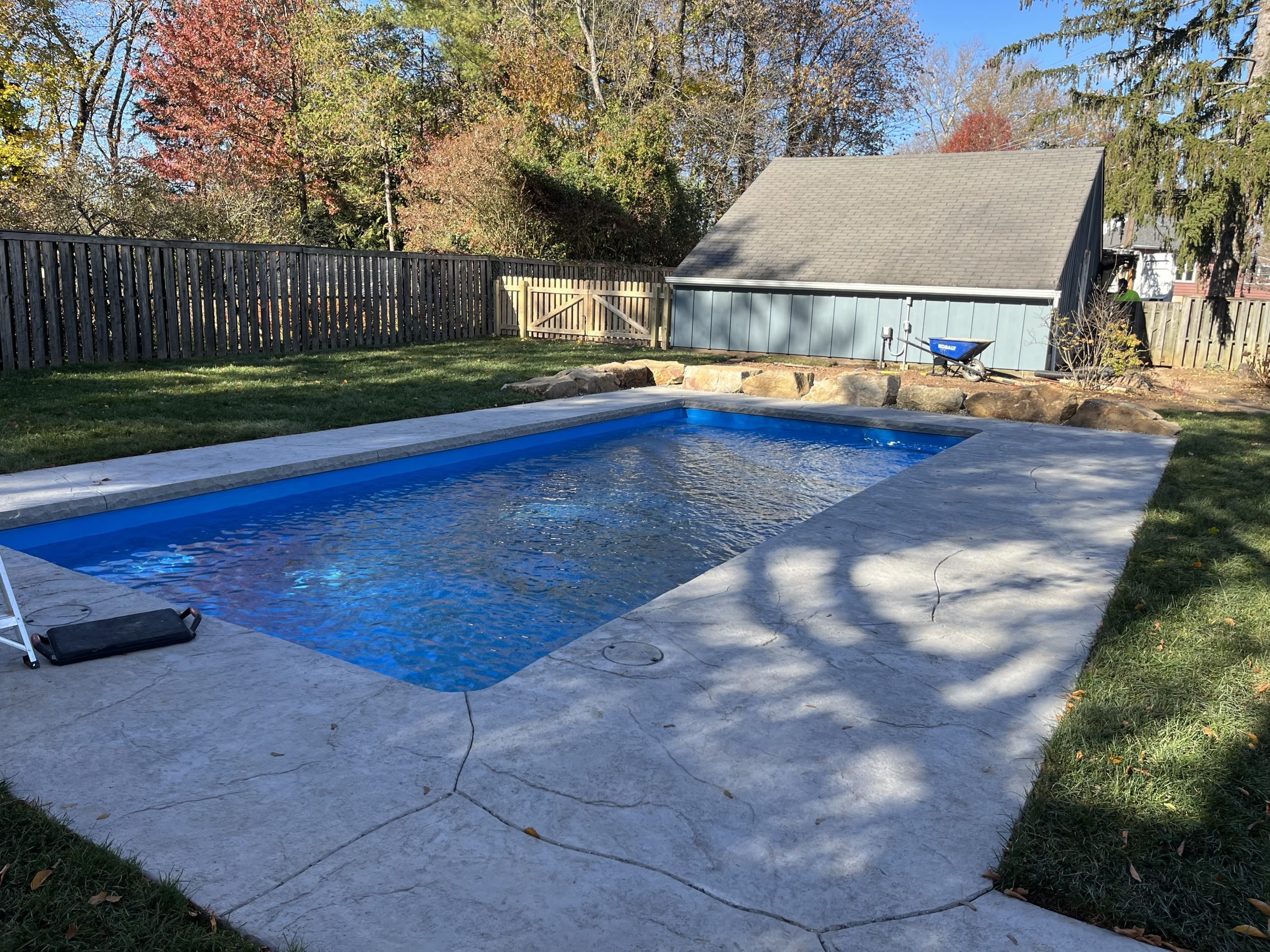 Rectangular in-ground swimming pool with freshly cleaned blue water and surrounding concrete deck.