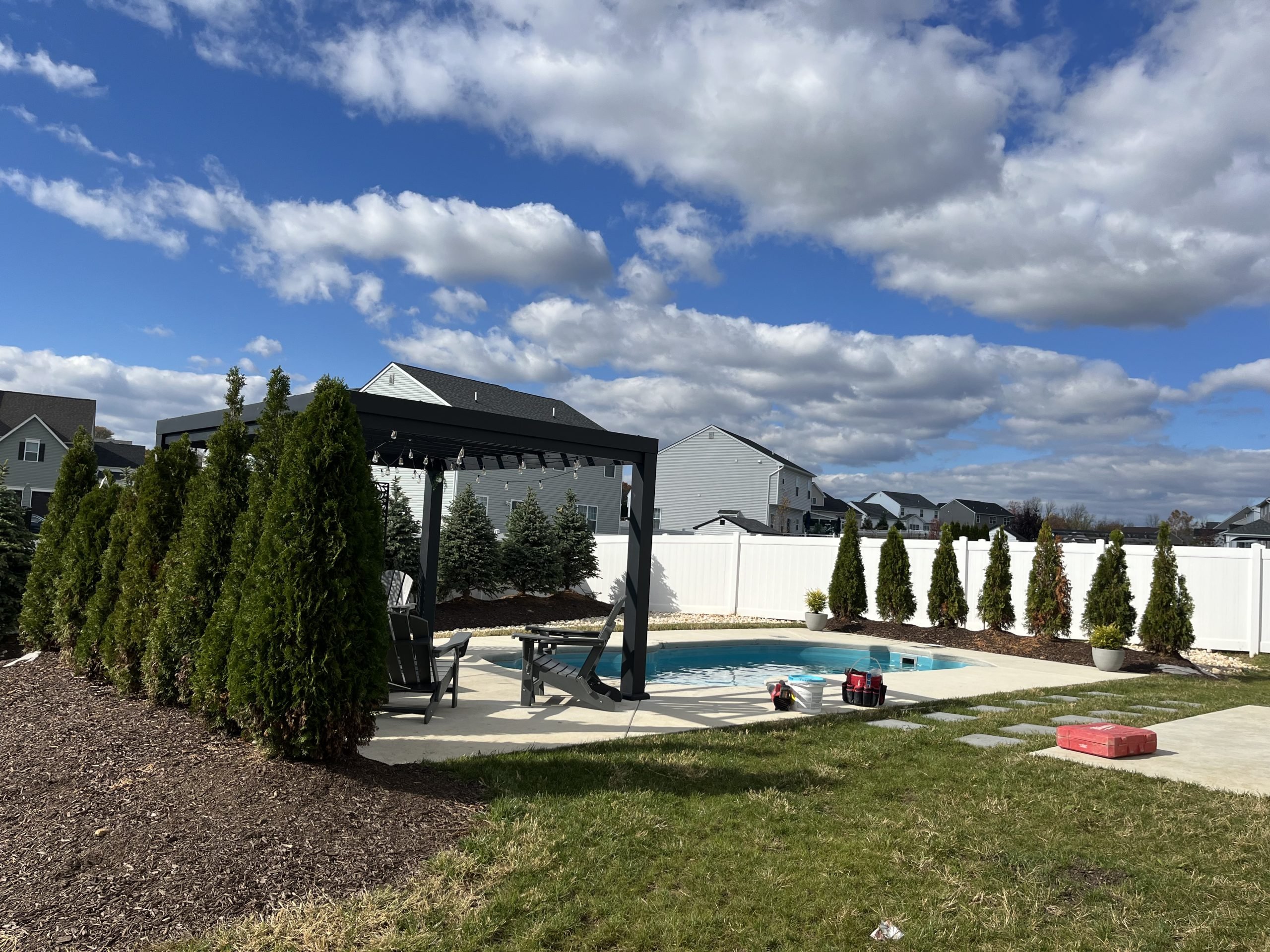 Residential swimming pool with landscaped backyard and sparkling clean water after routine pool maintenance.