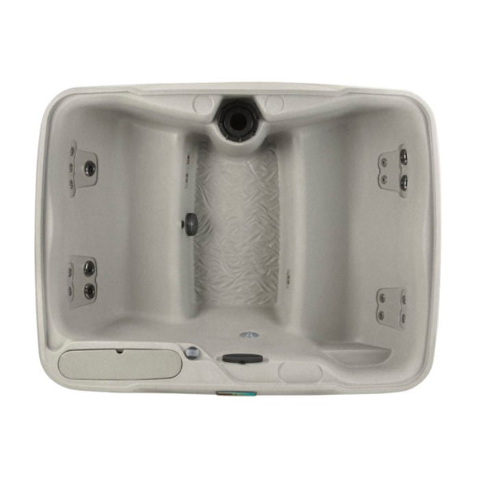 Direct top-down view of the Sand-colored Fantasy Spas Enamor hot tub, showcasing its facing bench seating layout, textured footwell, molded-in ice bucket, and hydrotherapy jets.