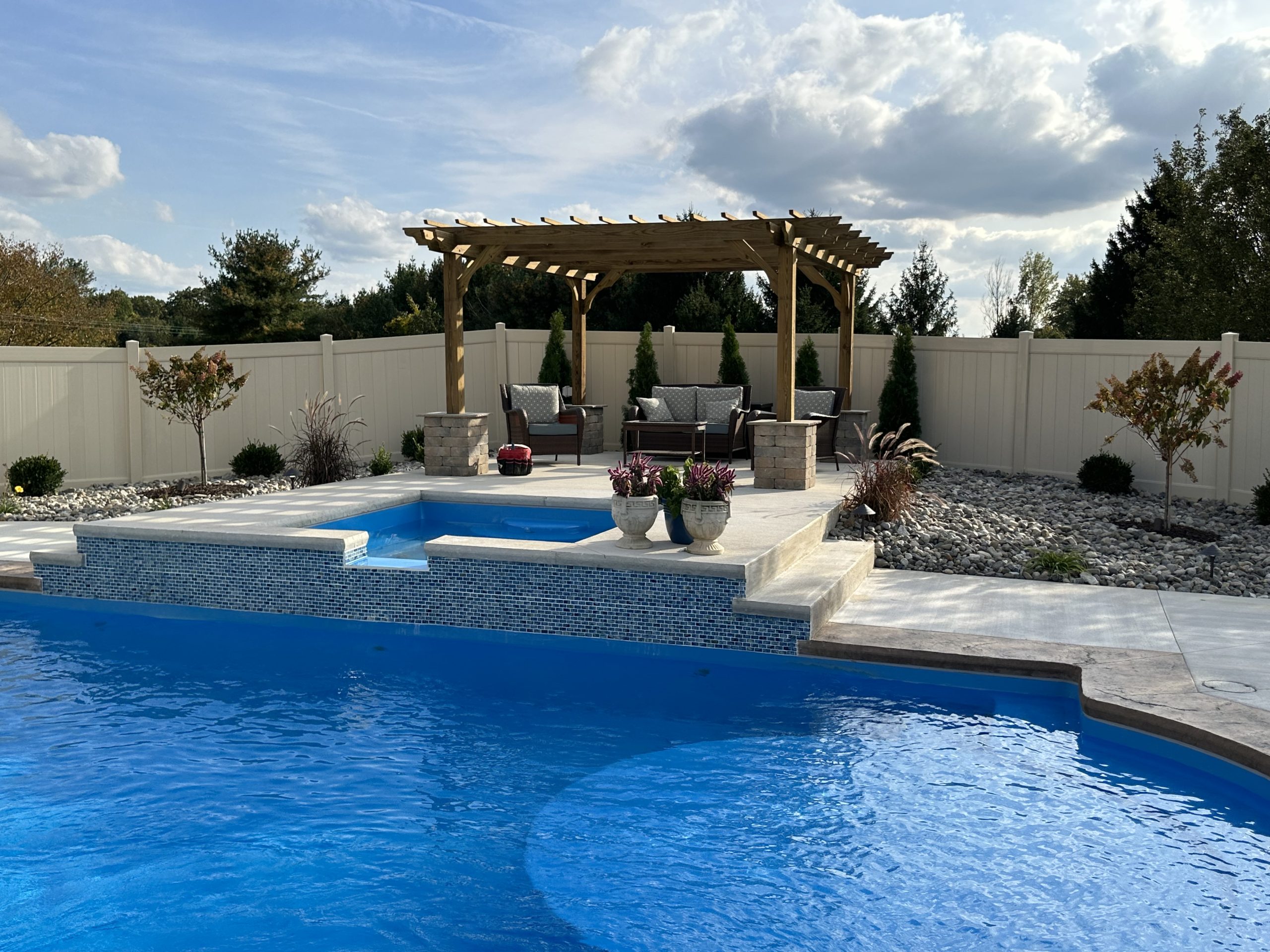 Modern in-ground swimming pool prepared for the swimming season with crystal-clear water and an outdoor patio.