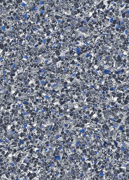 Close-up view of a vinyl pool liner pattern featuring a dense aggregate mosaic of fine slate grey, charcoal, and white crushed stones with subtle accents of royal blue.