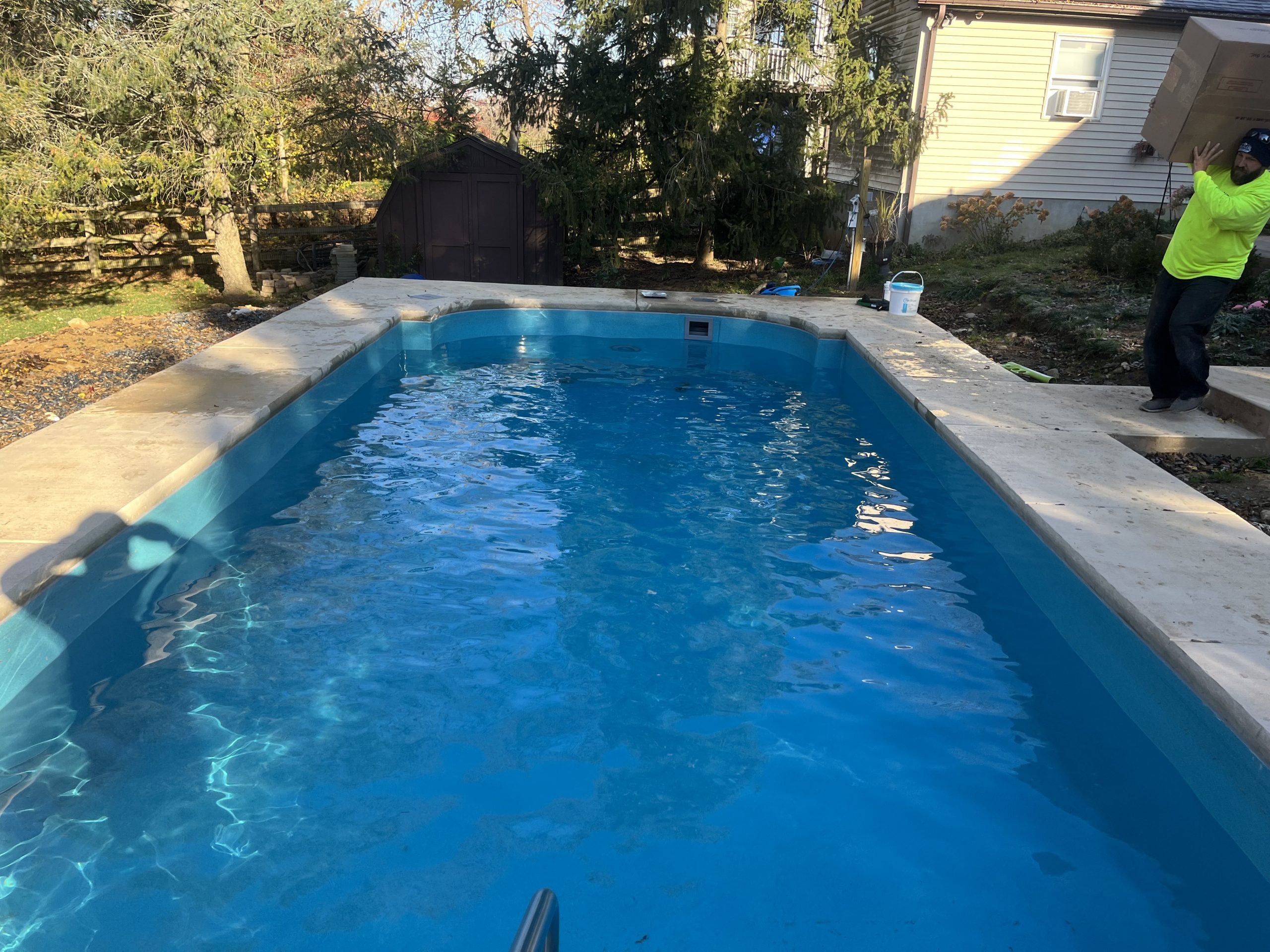 Rectangular in-ground swimming pool with freshly cleaned water following a professional pool opening service.